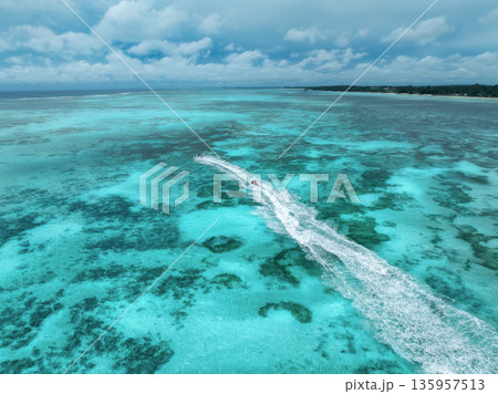 Aerial view of jet skis over shallow turquoise sea with reef Aerial view of jet skis over shallow turquoise sea with reef 135957513