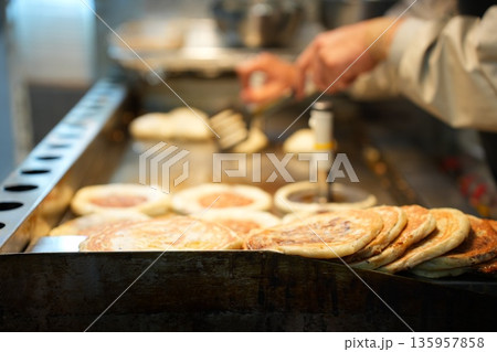 Hotteok Sweet Korean Pancake Being Cooked on a Griddle 135957858