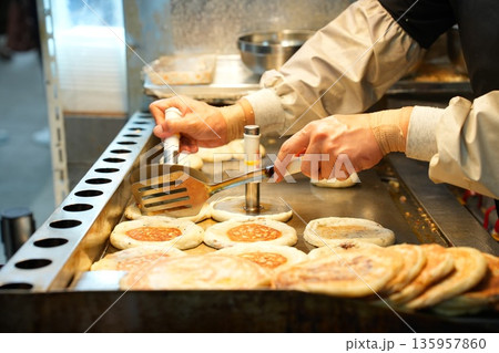 Hotteok Sweet Korean Pancake Being Cooked on a Griddle 135957860