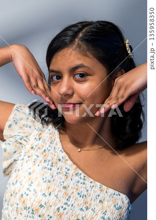 A young woman with a necklace and a flowery dress 135958350