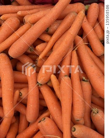 Fresh carrots piled together, showcasing vibrant orange color and smooth texture for background Fresh carrots piled together, showcasing vibrant orange color and smooth texture for background 135958586