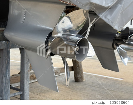 Boat propeller on dry dock showing sleek metal blades and mount, suitable for marine background Boat propeller on dry dock showing sleek metal blades and mount, suitable for marine background 135958604