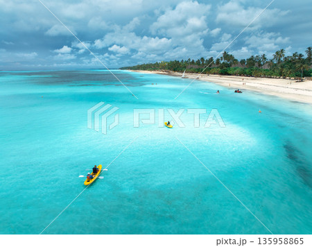 Aerial view of people kayaking in blue sea, tropical sandy beach 135958865