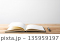 木の机に置かれた開いたノートとペン｜シンプルな背景と余白のある構図 135959197