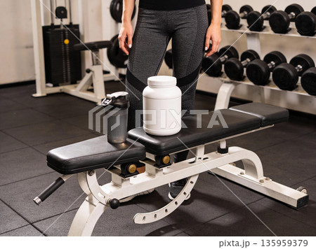 Fitness equipment and supplements on a bench in a gym, ready for a workout 135959379