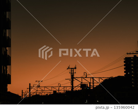 夕暮れの空と電線が連なる風景 135960042