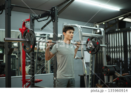 A man doing a squat and lifting weights A man doing a squat and lifting weights 135960914