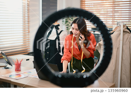 Fashion blogger concept, Young Asian women selling clothes and talking her smartphone with customer Fashion blogger concept, Young Asian women selling clothes and talking her smartphone with customer 135960960