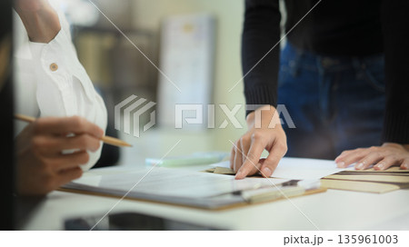 Two business people planing, consulting and meeting with paper work at office 135961003