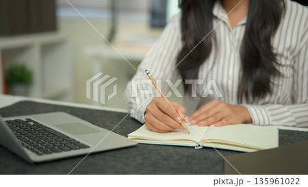 Closeup businesswoman hand working with writing on notebook 135961022
