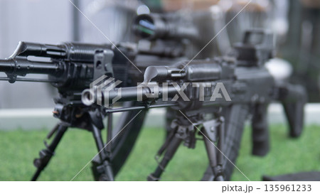 Photographic shot showcasing firearm assembly details, High resolution image capturing arrangement of contemporary firearms featuring tactical rails and supporting bipods 135961233