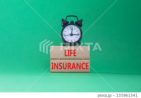 Life insurance symbol. Concept word Life insurance on wooden blocks. Beautiful green background with alarm clock. Business and Life insurance concept. Copy space Life insurance symbol. Concept word Life insurance on wooden blocks. Beautiful green background with alarm clock. Business and Life insurance concept. Copy space 135961341