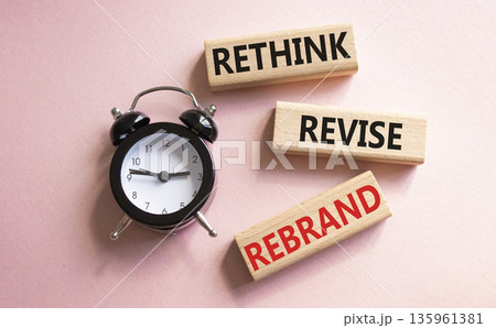 Rethink Revise Rebrand symbol. Wooden blocks with words Rethink Revise Rebrand. Beautiful pink background with alarm clock. Business and Rethink Revise Rebrand concept. Copy space. 135961381