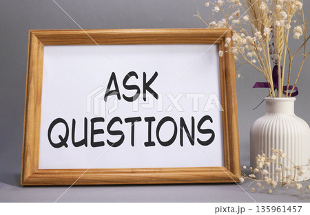 Ask Questions symbol. Concept words Ask Questions on beautiful wooden picture frame. Beautiful grey background with flower vase. Business and Ask Questions concept. Copy space. Ask Questions symbol. Concept words Ask Questions on beautiful wooden picture frame. Beautiful grey background with flower vase. Business and Ask Questions concept. Copy space. 135961457
