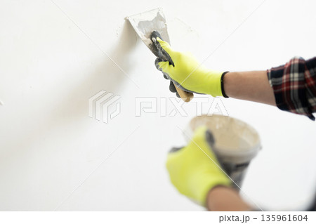 Worker Applying Wall Putty With Spatula Worker Applying Wall Putty With Spatula 135961604