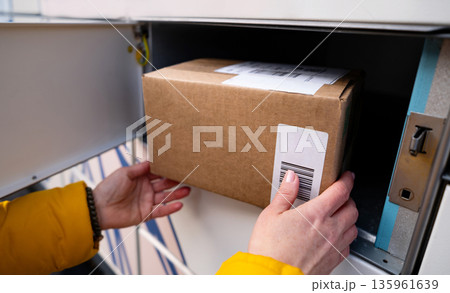 Girl Picking Up A Parcel From Parcel Automated Locker Girl Picking Up A Parcel From Parcel Automated Locker 135961639