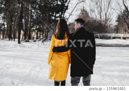 Couple walks together in snowy park while enjoying winter day 135961881