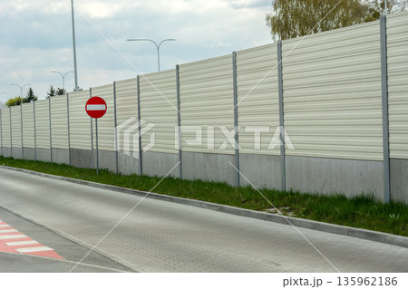 A prohibition road sign stands next to the noise barrier 135962186