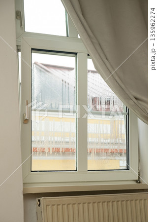 Plastic window with heavy condensation and water droplets. Indoor humidity problem Plastic window with heavy condensation and water droplets. Indoor humidity problem 135962274