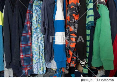 Close up of colorful casual clothes hanging in wardrobe Close up of colorful casual clothes hanging in wardrobe 135962290