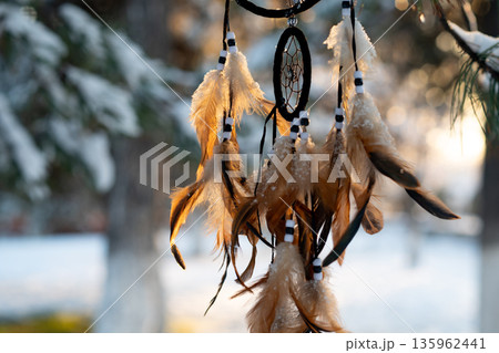 Dreamcatcher amulet outdoor, boho. American native amulet on sunset. Winter Dreamcatcher amulet outdoor, boho. American native amulet on sunset. Winter 135962441