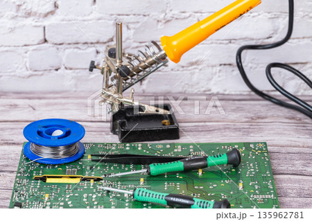 electrical board with a soldering iron and screwdrivers electrical board with a soldering iron and screwdrivers 135962781