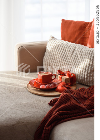 Heart Shaped Coffee Cup with Gift and Candies. Cozy Valentines Day Flatlay on Sofa Heart Shaped Coffee Cup with Gift and Candies. Cozy Valentines Day Flatlay on Sofa 135962966