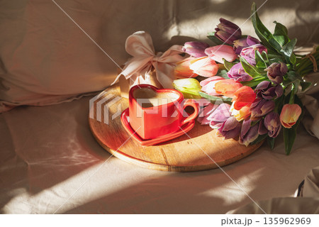 Heart Shaped Coffee Cup with Tulips on Bed. Romantic Valentines Day Celebration 135962969