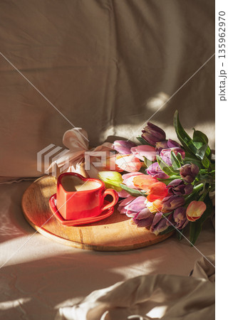 Heart Shaped Coffee Cup with Tulips on Bed. Romantic Valentines Day Celebration 135962970
