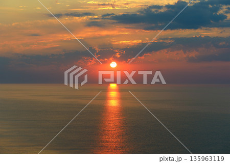 Majestic Sunset Over Calm Ocean Horizon with Golden Reflection Path Majestic Sunset Over Calm Ocean Horizon with Golden Reflection Path 135963119