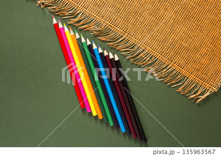 Set of colored pencils on a green background, top view 135963567