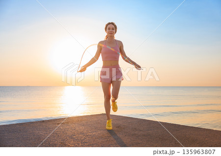 Fit woman jumping rope at the beach during summer vacation 135963807