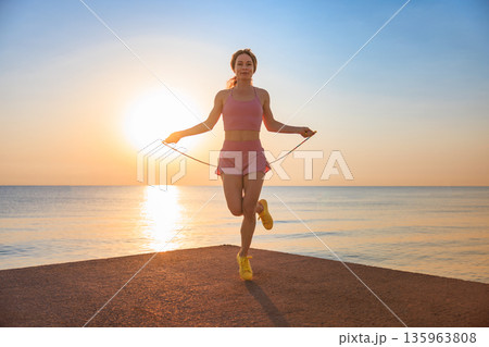 Fit woman jumping rope at the beach during summer vacation 135963808