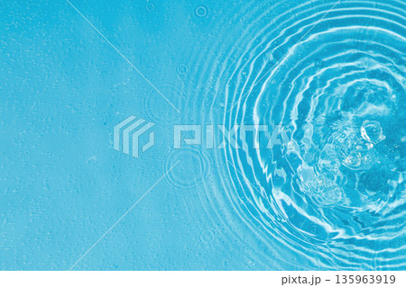 drops on water with circles on a blue background 135963919