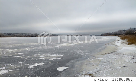 A frozen lake with a cloudy sky above 135963966