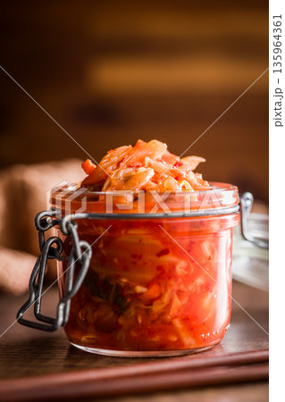 Fermented cabbage. Kimchi. Korean food in jar on wooden table. 135964361