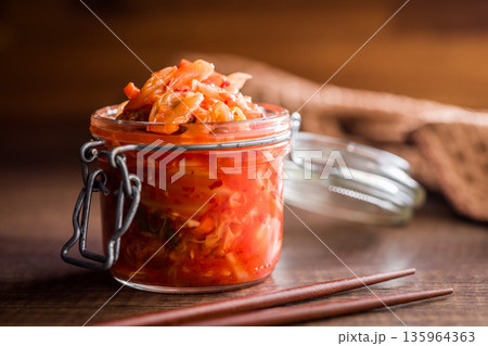 Fermented cabbage. Kimchi. Korean food in jar on wooden table. 135964363