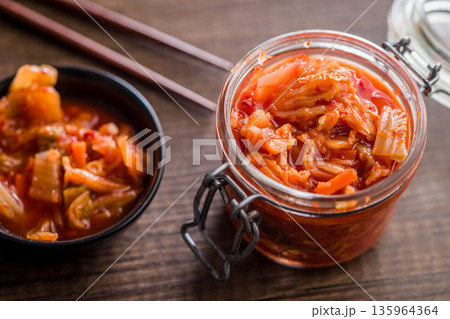 Fermented cabbage. Kimchi. Korean food in jar on wooden table. 135964364