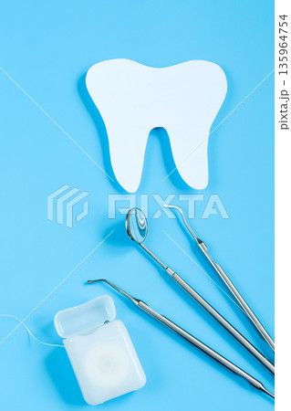 Paper cut mockup of tooth and dental instrument on blue background. Dental care concept. International Dentist Day. 135964754