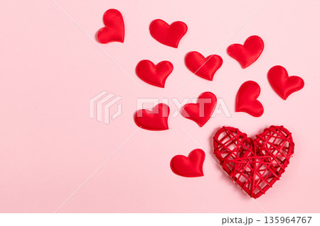 Red hearts on a pink background. Minimalistic concept for valentine's day. Place for your text. Red hearts on a pink background. Minimalistic concept for valentine's day. Place for your text. 135964767