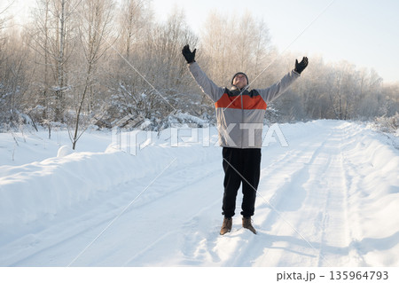 Man with raised arms enjoying winter snow road Man with raised arms enjoying winter snow road 135964793