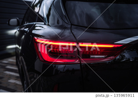 Modern Black Car Rear Taillight Close Up at Night Modern Black Car Rear Taillight Close Up at Night 135965911