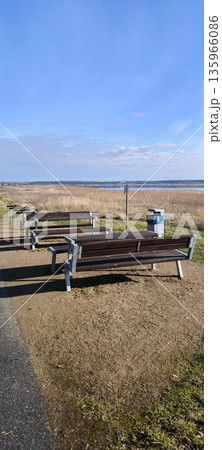 Wooden benches and tables for relaxing on the lake shore Wooden benches and tables for relaxing on the lake shore 135966086