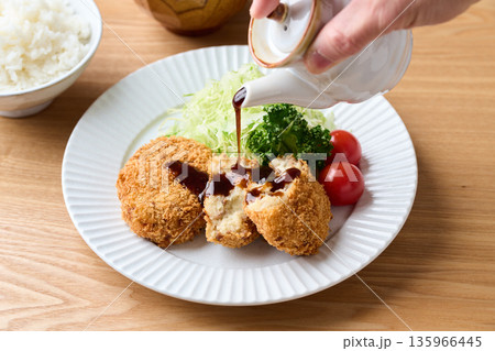 ポテトコロッケにソースをかける 135966445
