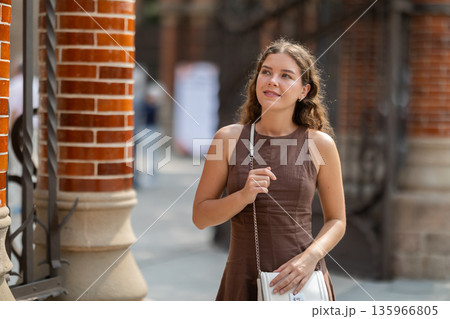 Young woman standing near the metal fence Young woman standing near the metal fence 135966805