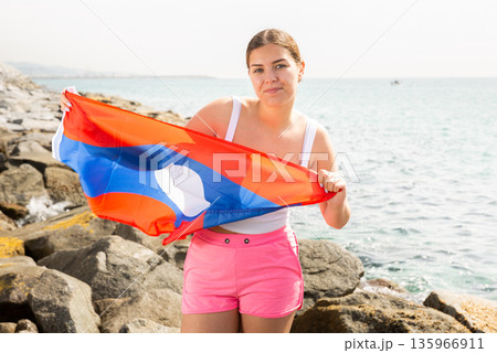 Young woman on coast posing with flag of Laos Young woman on coast posing with flag of Laos 135966911