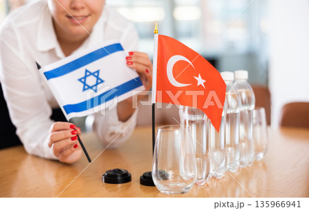 Little flag of Turkey on table and flag of Israel put next to it by young woman Little flag of Turkey on table and flag of Israel put next to it by young woman 135966941