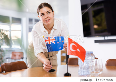 female assistant prepares conference room for diplomats of Turkey and Australia 135967000