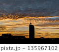Silhouette of modern skyscraper against dramatic golden sunset sky 135967102