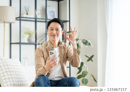 リビングでスマホを使うミドルの男性 135967157